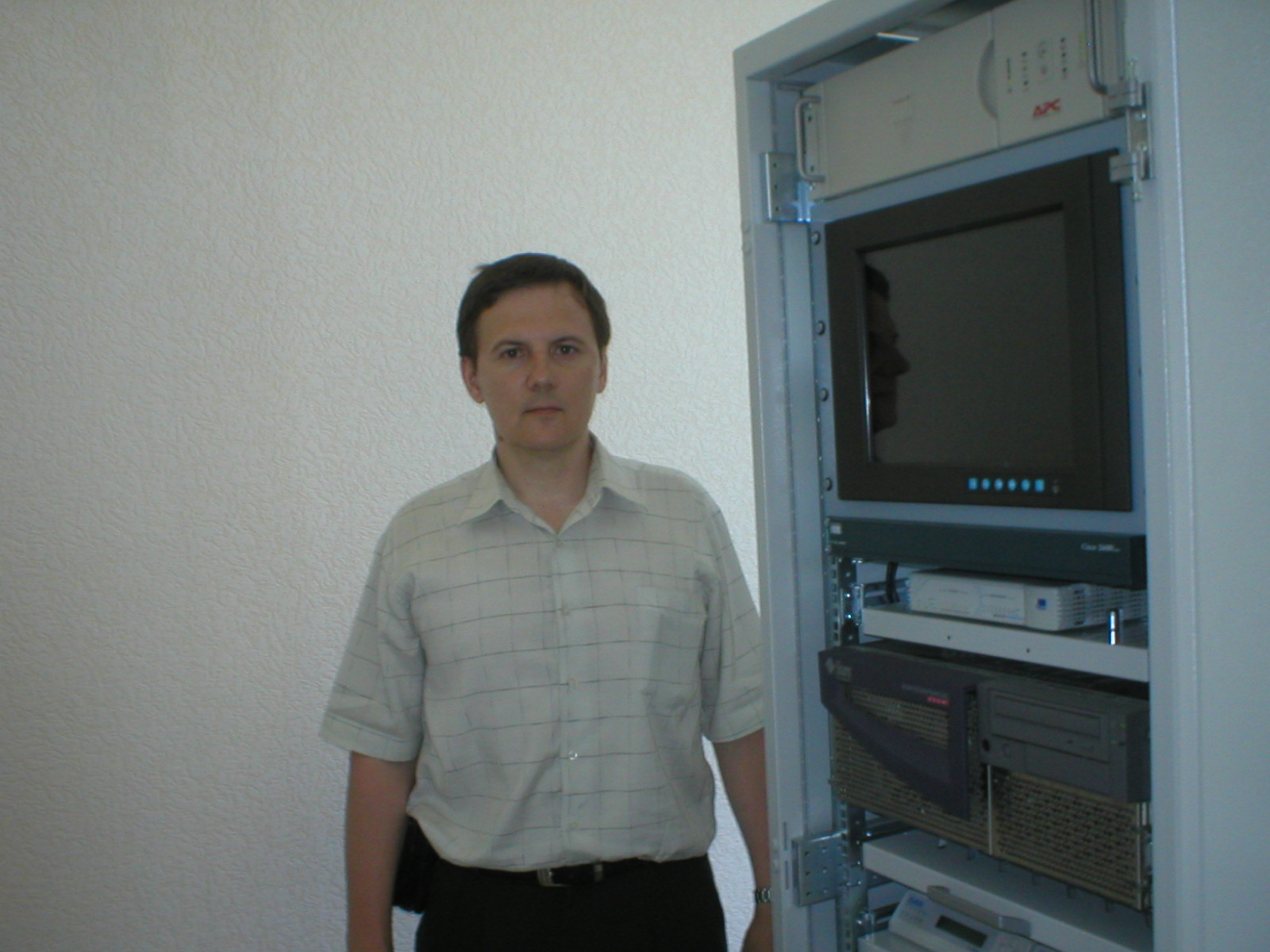 Dr. Andrew, Senior Researcher, standing next to Control and Correction Station equipment in the navigation systems laboratory